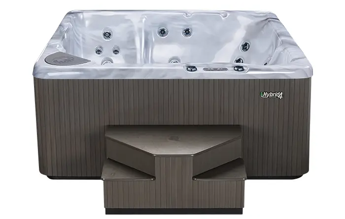 A Beachcomber hybrid hot tub with a grey cabinet and matching steps