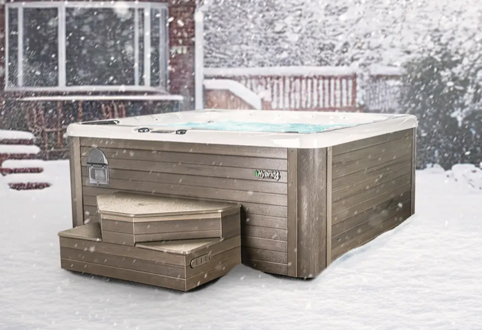 A hot tub with steps set up in a snowy backyard