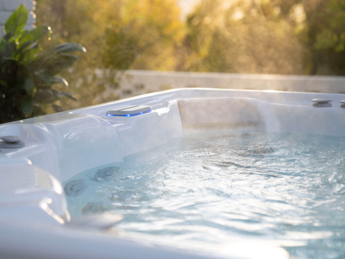 Close-up of clear, calm hot tub water with the headrest and jets behind